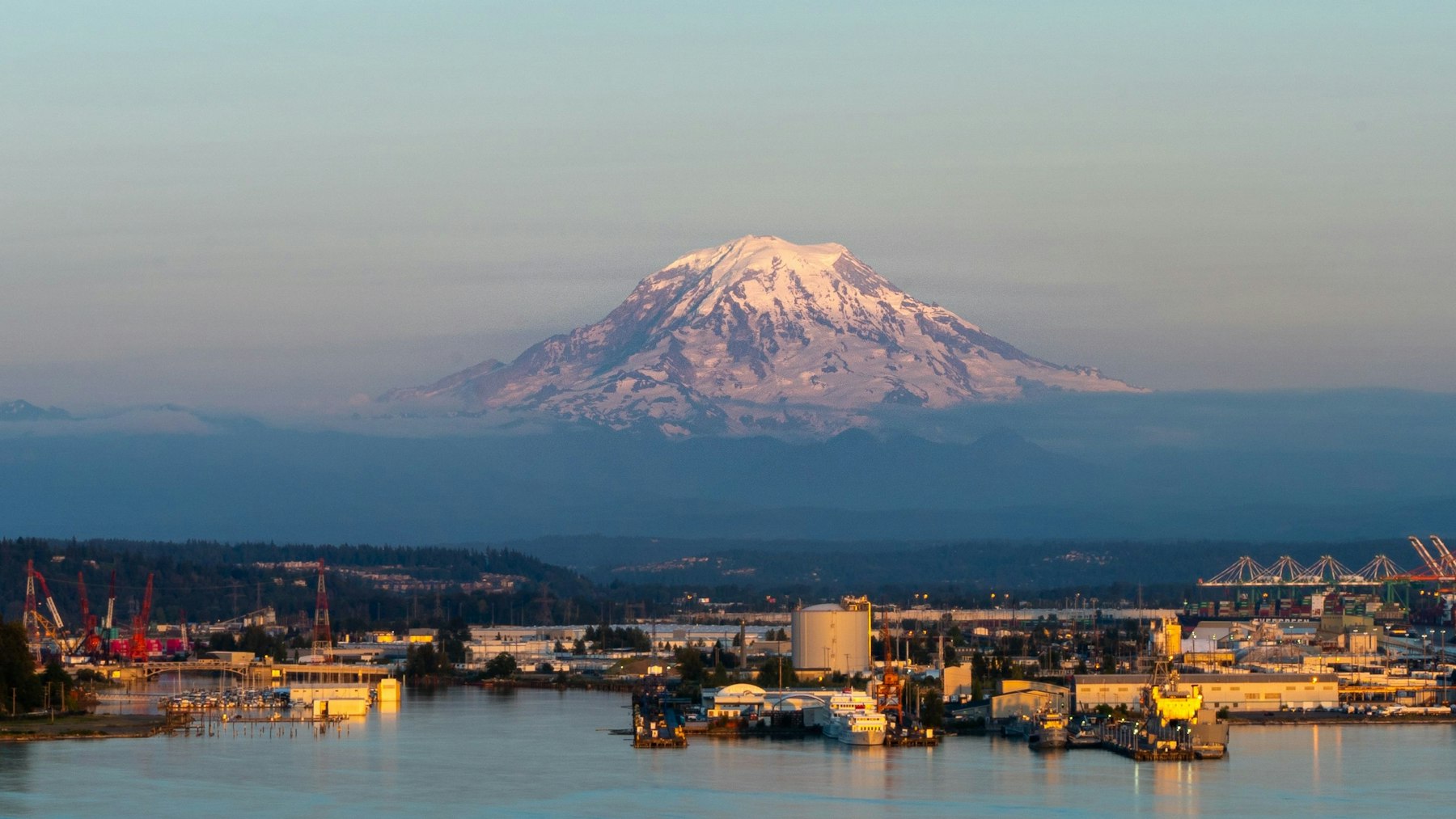 Mount Rainier glowing at dusk above the Port of Tacoma waterfront in Pierce County, Washington